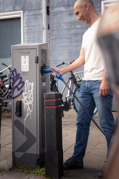 Homme utilisant un câble de recharge à une borne pour voiture électrique