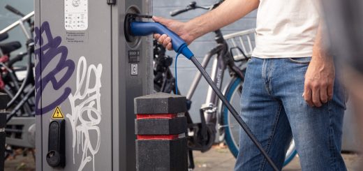 Homme utilisant un câble de recharge à une borne pour voiture électrique