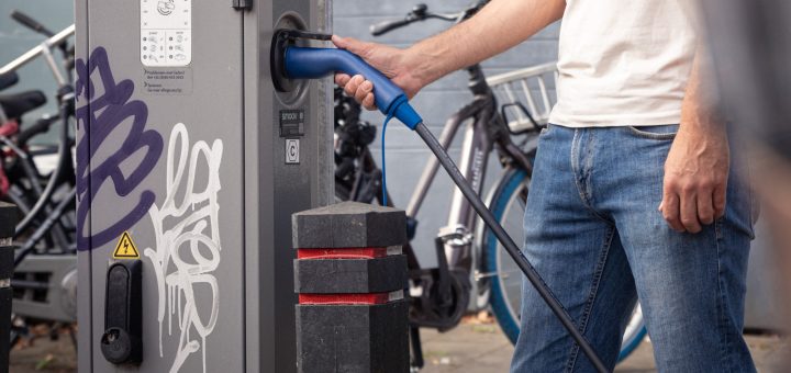 Homme utilisant un câble de recharge à une borne pour voiture électrique