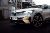 Voiture renault grise de face proche d'un bâtiment industriel désaffecté