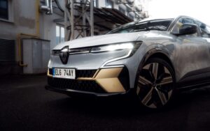 Voiture renault grise de face proche d'un bâtiment industriel désaffecté