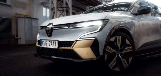 Voiture renault grise de face proche d'un bâtiment industriel désaffecté